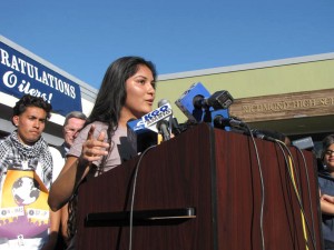 talk Richmond High senior Norma Bautista speaks at a news conference at the school Wednesday. The signs behind her read, "RICHMOND CARES!", "WHAT ABOUT THE GOOD THINGS?!", and "WE ARE AGAINST VIOLENCE."