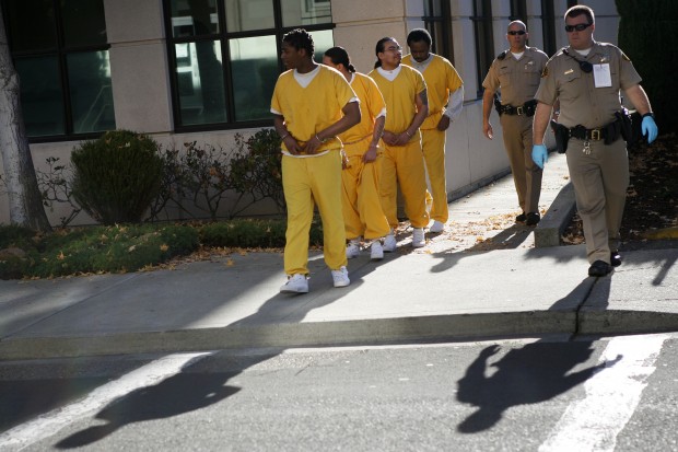 County sheriff's deputies escort defendants Marcelles Peter, Jose Montano, Elvis Torrentes, and John Crane Jr. to the courthouse.