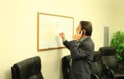 County Supervisor John Gioia writes the ballot results for Measure J on a board as county election officials phone in the results. Measure J will help raise about $5 million in revenue through a parcel tax for Doctors Medical Center in San Pablo, which will help the hospital avoid closure. (Photo by Hasan Dudar)