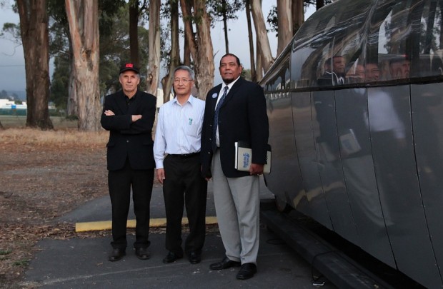 CyberTran CEO Neil Sinclair, Chief Technical Officer Eugene Nishinaga and Executive Vice President Dexter Vizinau stand next to a model cybertran parked next the company’s front door.