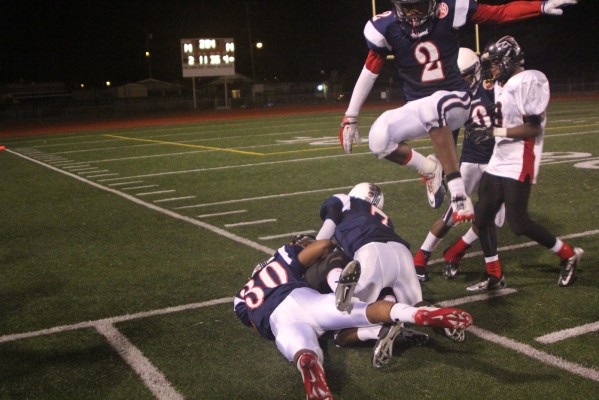 Deshawn Clark shows off his jumping ability as he leaps over a pile of players. (Photo: Stephen Hobbs)