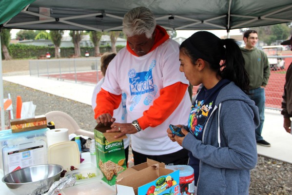 Morena Pereira, a sophomore at Salesian High School, checks out the snack table with one of the event organizers, Steve Salcido. Pereira said she walked all 12 laps. “It’s pretty cool,” she said. “ I didn’t know it was going to be this big.” (Photo by: Brittany Patterson)