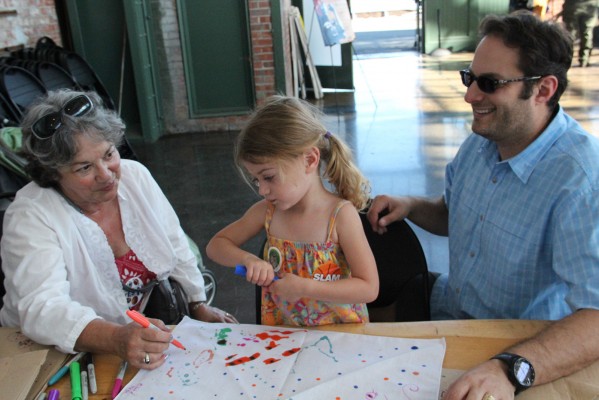 Elie Zoffel spent a long time designing her Rosie-esque style hair scarf. Around the Craneway Pavilion community groups provided interactive education for kids and families. (Photo by: Jennifer Baires)
