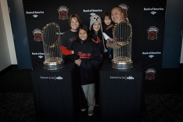 Alan Kwong, of Richmond, stands with his family as they have their photo taken with the two World Series trophies. "I've been a giants fan 20-something years," he said. "And just to be [living] in this era of two in three years—it's just good to be apart of it." (Photo by: Tyler Orsburn)