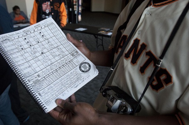 Marc Jordan wanted his photo taken with the logbook he kept for the first game of the World Series. "Stats are very important to me,"he said. "I definitely get closest to the game by scoring it." (Photo by: Tyler Orsburn)