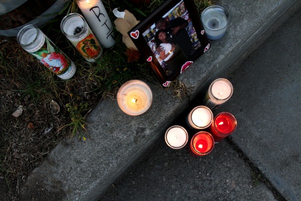 Candles and a photo of Dimarea Young and his girlfriend at the edge of a lawn where Young was gunned down.