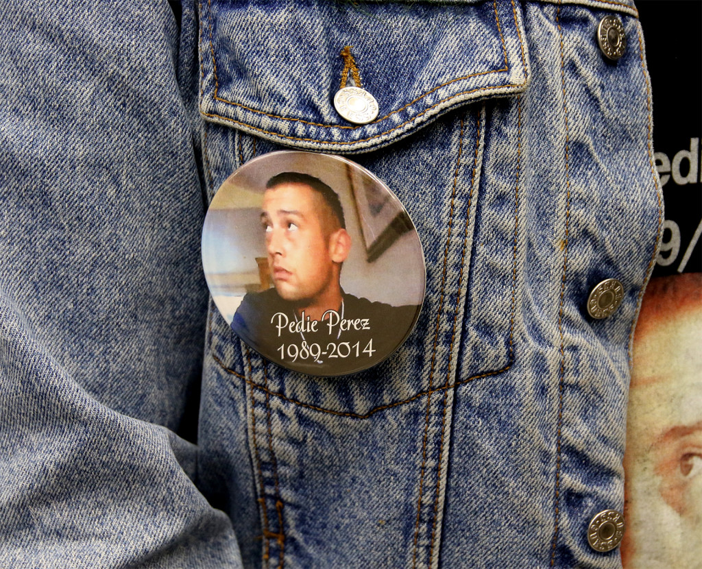 A button with the face of Pedie Perez, affixed to a denim jacket pocket.